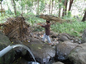 Seorang ibu pencari kayu bakar melintas di sumber mata air hutan Mekar Sari